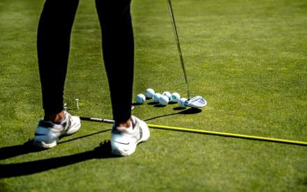 A picture of someone practising their putting at Overstone Park Resort's golf course